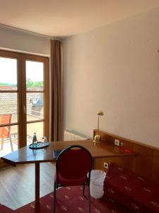 Zimmer mit einem Schreibtisch, einem Tisch und einem Stuhl in der Unterkunft Hotel Erlenbacher Hof in Bad Homburg vor der Höhe