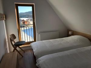 1 dormitorio con cama, ventana y silla en CASA SMIDA JAZZ en Smida