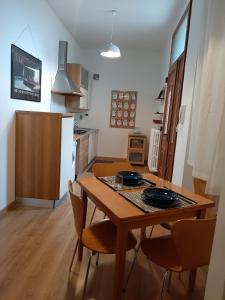 uma cozinha com uma mesa de madeira e cadeiras num quarto em Genio em Bolonha