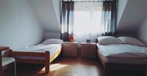 2 camas en una habitación pequeña con ventana en Marina Niedźwiedzi Róg en Ruciane-Nida