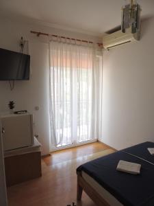 a bedroom with a bed and a large window at Villa Šutić in Promajna