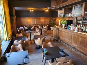 a restaurant with tables and chairs and a bar at Hotel Maurice in Nieuwvliet