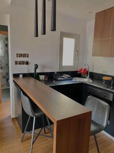 a kitchen with a wooden counter top and chairs at Pearl City View Apartment in Paphos