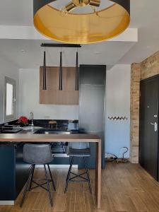 une cuisine avec une table et deux tabourets de bar dans l'établissement Pearl City View Apartment, à Paphos