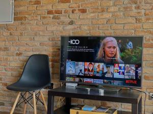 a flat screen tv sitting on a table next to a brick wall at Pearl City View Apartment in Paphos