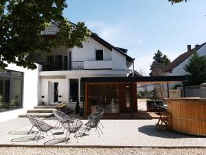 patio z krzesłami przed domem w obiekcie A16 Design Panzió w mieście Harkány