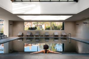 a woman sitting in a swimming pool at Monte Santo Resort in Carvoeiro