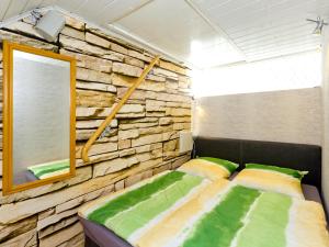 a bedroom with a stone wall and a bed at FeWo Weltenbummler in Dorum