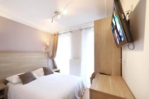 a bedroom with a bed and a flat screen tv at Luxelthe in Paris