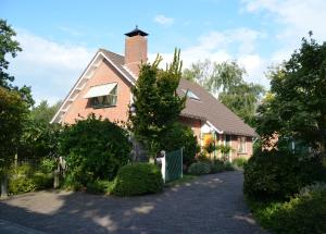 a brick house with a chimney and a driveway at De strandkamer in Oostkapelle