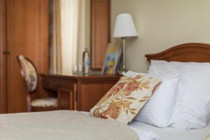 a bedroom with a bed with a desk and a pillow at Heritage Hotel Frankopan in Ogulin