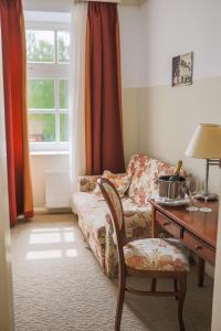 uma sala de estar com um sofá e uma secretária e uma mesa e cadeira em Heritage Hotel Frankopan em Ogulin