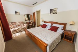 um quarto de hotel com uma cama e um sofá em Heritage Hotel Frankopan em Ogulin