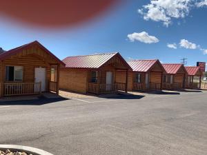 a row of wooden cabins with red roofs at Red Canyon Cabins in Kanab