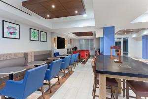 a dining room with tables and blue chairs at Holiday Inn Express Elk Grove West I-5, an IHG Hotel in Elk Grove