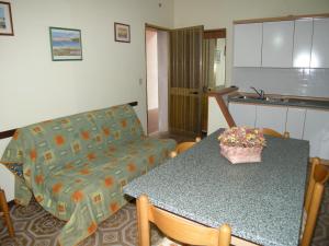 ein Wohnzimmer mit einem Tisch und einem Sofa in der Unterkunft Villa Milviana appartamento in Rosolina Mare