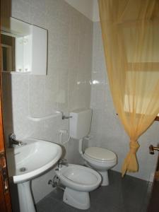 y baño con aseo blanco y lavamanos. en Villa Milviana appartamento, en Rosolina Mare