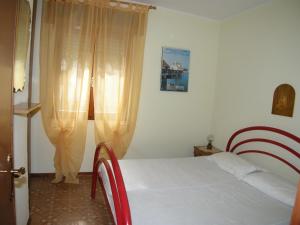 a bedroom with a white bed and a window at Villa Milviana appartamento in Rosolina Mare