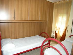 1 dormitorio pequeño con 1 cama y 2 sillas en Villa Milviana appartamento, en Rosolina Mare