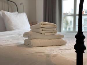 una pila de toallas sentadas encima de una cama en B&B De Grote Kade I Bella Zeelandia en Goes