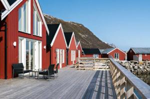 a wooden deck with chairs and a table on a building at Rorbu i Lofoten in Leknes