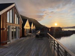 eine Holzterrasse mit einem Sonnenuntergang im Hintergrund in der Unterkunft Rorbu i Lofoten in Leknes