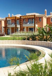 a house with a swimming pool in front of a house at Monte Santo Resort in Carvoeiro