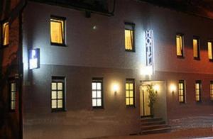 un edificio con ventanas iluminadas y escaleras delante de él en City Hotel, en Ludwigsburg