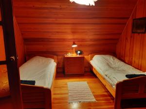 - une chambre avec 2 lits dans une cabane en bois dans l'établissement Dom na Skraju Lasu, à Stoczek Łukowski