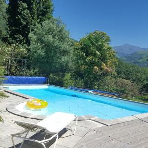 uma piscina com duas cadeiras e um frisbee em Villa de 3 chambres avec piscine privee jardin clos et wifi a Aspin en Lavedan em Aspin-en-Lavedan