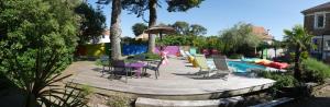 - une piscine avec des chaises, une table et un parasol dans l'établissement Le Gage location de vacance à la semaine, à Saint-Brévin-lʼOcéan
