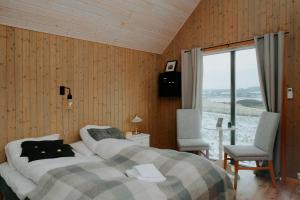 a bedroom with a bed and a large window at Husfrua Gårdshotell in Straumen