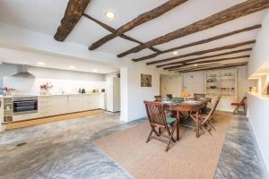 eine Küche und ein Esszimmer mit Tisch und Stühlen in der Unterkunft Beach Golf & Garden House in Arcozelo