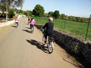 um grupo de pessoas andando de bicicleta por uma estrada em Bed & Breakfast La Collinetta em Locorotondo