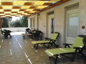 une terrasse couverte avec des chaises et des tables ainsi qu'un plafond dans l'établissement Bed & Breakfast La Collinetta, à Locorotondo