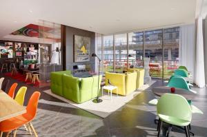 a lobby with colorful chairs and tables in a building at citizenM Paris La Défense in Nanterre