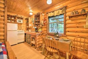 Cozy Davis Cabin with Deck - Nestled by Honey Creek! في Davis: مطبخ بجدران خشبية وطاولة وكراسي