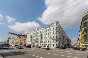 a large white building on a city street with cars at Oksana's Apartments - Nevsky 64 in Saint Petersburg