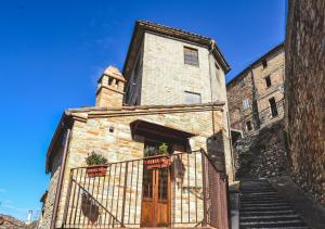 - un vieux bâtiment en pierre avec une porte et des escaliers en bois dans l'établissement Villa Schinoppi, à Amandola