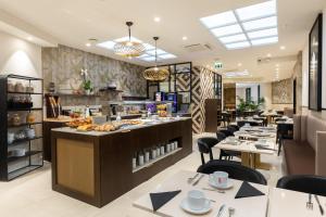 a restaurant with a buffet line with tables at Best Western Plus Hôtel Massena Nice in Nice
