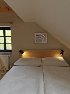 1 Schlafzimmer mit 2 weißen Betten im Dachgeschoss in der Unterkunft Apartmány Slunce in Osečná