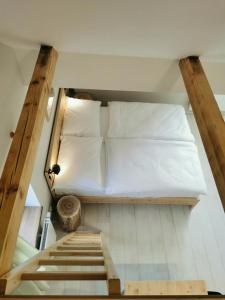 ein kleines Schlafzimmer mit einem Bett und einer Treppe in der Unterkunft Apartmány Slunce in Osečná
