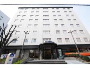 um edifício branco com a entrada para ele em Hotel Shin Osaka / Vacation STAY 81525 em Osaka