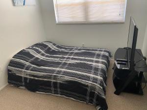 a bedroom with a bed and a desk and a television at Private room in a 2 bedroom 1 bathroom shared with host, on the beach, surrounded by resorts, only 2 people MAX in St Pete Beach