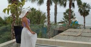 a woman standing on a balcony looking at the ocean at H Boutique Peña Parda in La Herradura