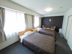 a hotel room with two beds and a window at Hotel Shin Osaka / Vacation STAY 81541 in Osaka