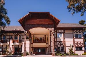 ein Gebäude mit einem Torbogen davor in der Unterkunft Hotel Jardins da Colina in Nova Petrópolis