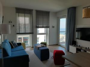 a living room with a blue couch and a tv at Residenz Bollwark Port Olpenitz in Kappeln