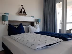a bedroom with a bed with blue and white pillows at Residenz Bollwark Port Olpenitz in Kappeln