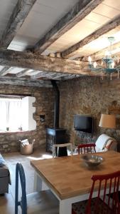 RuiseñadaにあるCASA TINAのテーブルと石の壁のあるリビングルーム